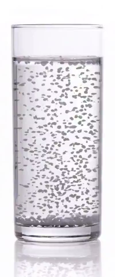 A glass of water from a carbon filter jug, with soft grey particles